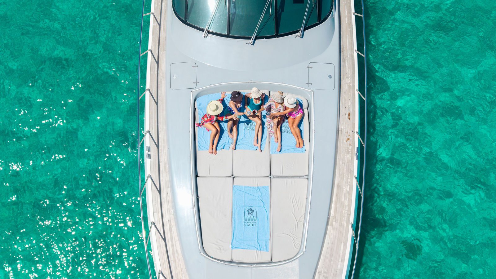 Guests on the KayDee bow sunpad aerial view Bahamas yacht charter