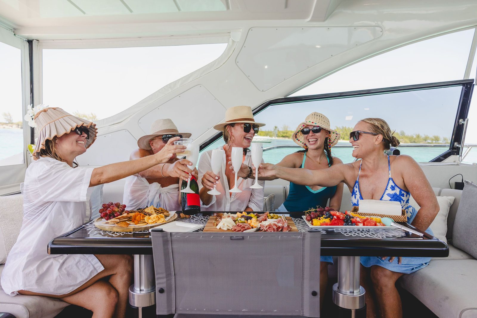 Guests toasting aboard KayDee Mangusta 80 private yacht charter Bahamas